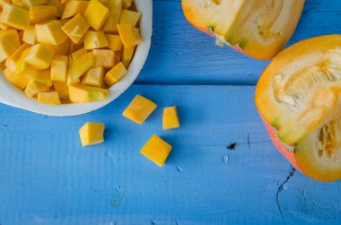 Sonbahar çiğ kabak mavi ahşap arka plan üzerine dilimlenmiş