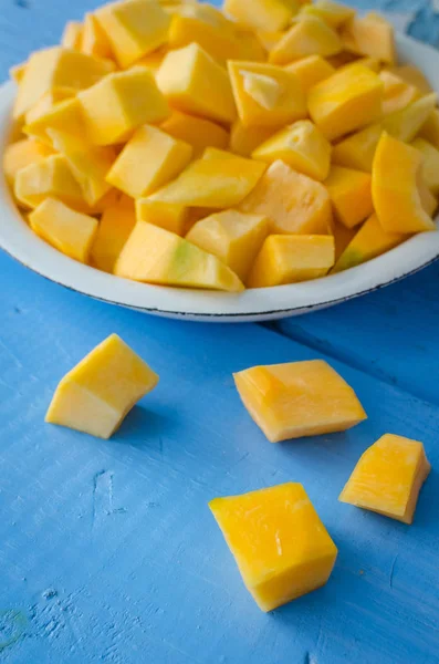 Sonbahar çiğ kabak mavi ahşap arka plan üzerine dilimlenmiş