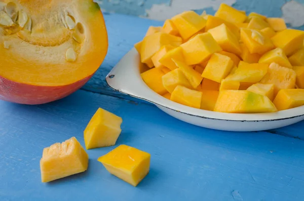 Sonbahar çiğ kabak mavi ahşap arka plan üzerine dilimlenmiş