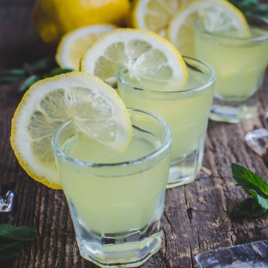 Italian traditional liqueur limoncello with lemon clipart