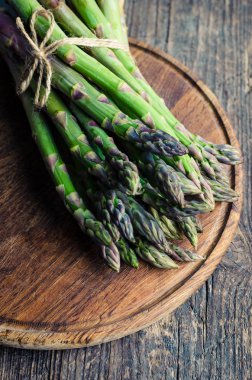 Demet taze yeşil kuşkonmaz ile sicim eski masa ahşap tahta üzerinde bağlıdır. Sağlıklı gıda kavramı.