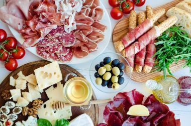 Akdeniz mezeleri, tapas ya da antipasto dolu bir masa. Çeşitli İtalyan yemek takımları. Partide ya da piknikte lezzetli atıştırmalıklar. Et ve peynirli kıyma tahtası. İtalyan usulü ziyafet. Üst görünüm.