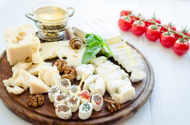 Peynir tabağı: Parmesan, kaşar peyniri, gouda, gorgonzola, brie ve diğer ceviz ve beyaz arka plan üzerinde ahşap tahta üzerinde tatlım. Lezzetli meze peynir farklı tipteki.