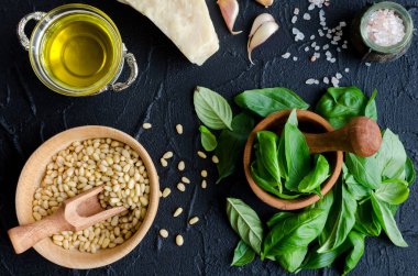 Taze malzemeler yukarıda siyah taş zemin üzerine pesto Cenevizli sos için. Parmesan peyniri, fesleğen yaprağı, çam fıstığı, zeytin yağı, sarımsak ve tuz. Geleneksel İtalyan mutfağı. Üstten Görünüm.
