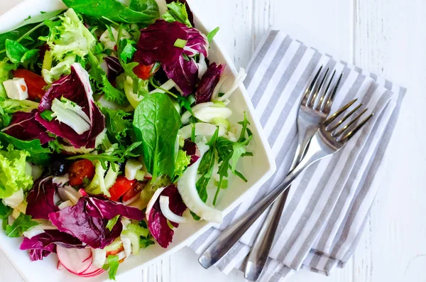 新鲜的夏日绿色沙拉 配以色拉生菜 西红柿 菊苣和芝麻菜 用木制背景的叉子在白色的碗里 健康饮食观念 顶部视图 — 图库照片