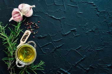 Otlar ve baharatlar seçimi - biberiye, sarımsak, limon, tuz, karabiber ve zeytinyağı karanlık taş masada. Gıda düz yatıyordu. Metin için yer ile yaratıcı düzeni. Uzay kopyalayın. Üstten Görünüm.