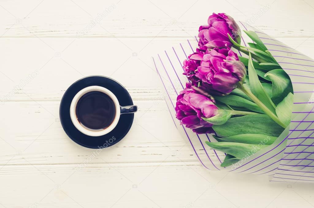 Cup of morning coffee and bouquet of spring flowers