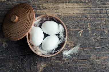 Metin için boş yer eski rustik ahşap zemin üzerine kasede yumurta. Mutlu Paskalya tatili. Üstten Görünüm. Kopya alanı.