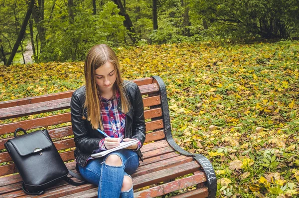 Красива школярка-підліток навчається в парку — стокове фото
