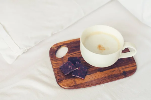 Kopje cappuccino op het bed — Stockfoto