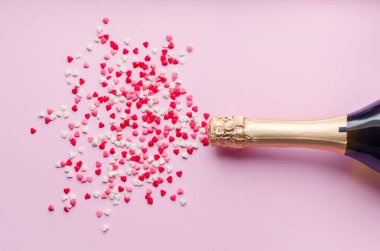 Pembe arka planda şampanya şişesi