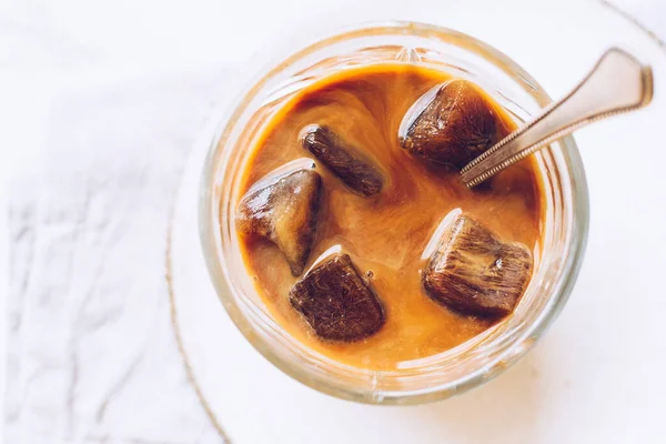 Bir sürahiden bir bardak espresso buz küplerine süt dökmek — Stok fotoğraf