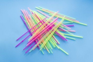 Colored plastic drinking straws on a blue background