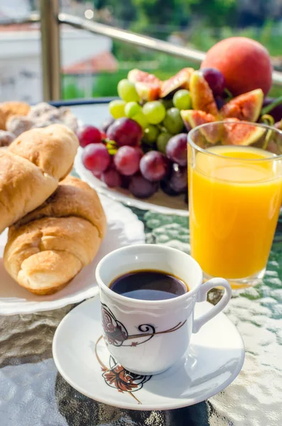 Τραπεζάκι πρωινού με καφέ, χυμό πορτοκάλι, φρούτα και κρουασάν — Φωτογραφία Αρχείου