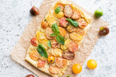 Renkli domatesli, kirazlı, peynirli ve fesleğenli sebzeli börek. Vejetaryen sağlıklı gıda konsepti. Üst görünüm.