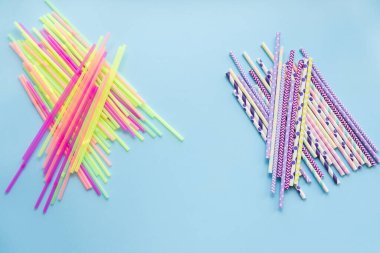 Plastik, kağıda karşı mavi arka planda pipet içiyor. Sıfır sürdürülebilir yaşam, plastiksiz konsept. Eko dostu plastik eşyalar. Tekrar kullan, azalt, reddet. Üst görünüm.