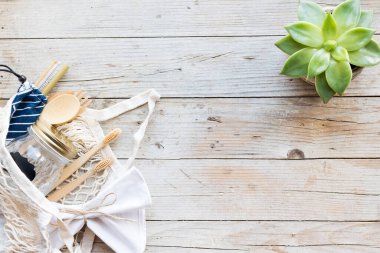 Sıfır atık. Pamuk torbaları, cam kavanoz, bambu çatal bıçak takımı ve tahta arka planda diş fırçası. Sürdürülebilir yaşam. Eko dostu plastik eşyalar. Üst Manzara. Boşluğu kopyala.
