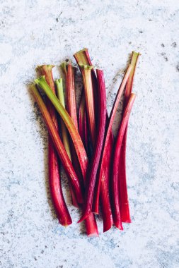 Gri arka planda taze koparılmış organik ravent sapları. Üst görünüm.