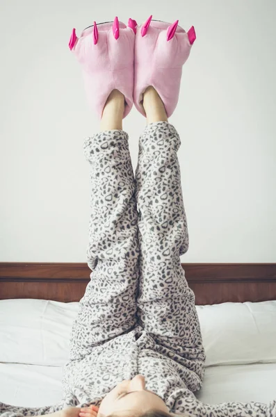 아침을 즐기는 귀엽고 잠옷을 분홍색 몬스터 슬리퍼를 있었고 침대에 있었다 — 스톡 사진