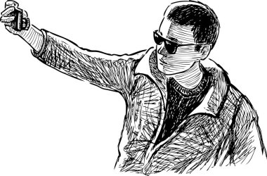 Güneş gözlüklü genç adamın akıllı telefonuyla selfie çektiği bir resim.