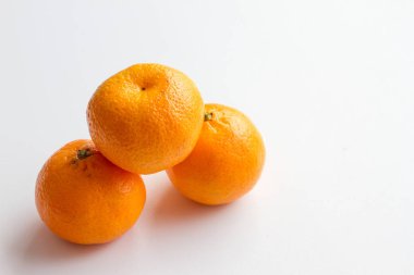 Beyaz arka plan üzerinde izole mandarin. Piramit üç olgun mandalina.