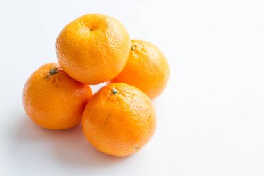 Beyaz arka plan üzerinde izole mandarin. Dört olgun mandalina Piramidi.