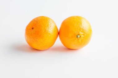 Beyaz arka plan üzerinde izole mandarin. İki Olgun mandalina etrafında yalan.