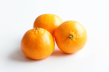 Beyaz arka plan üzerinde izole mandarin. Etrafta üç olgun mandalina.