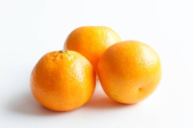 Beyaz arka plan üzerinde izole mandarin. Etrafta üç olgun mandalina.