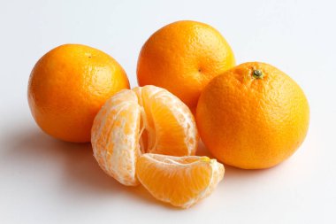 Beyaz arka plan üzerinde izole mandarin. Dört Mandarin yalan yan yana. Bir soyulmuş mandalina ve Mandarin bir dilim.
