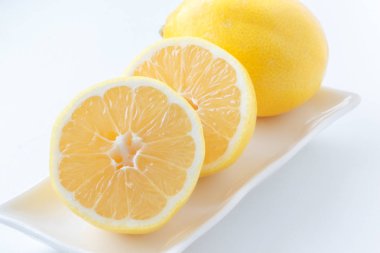 Limon yarım kesilmiş. Tamamlayan bir plaka üzerinde bir limon yanında yalan limon.