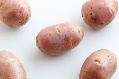 Bir sürü pis patateslerin üzerine beyaz bir arka plan. Beyaz bir arka plan üzerinde dağınık patates.