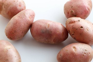 Bir sürü pis patateslerin üzerine beyaz bir arka plan. Beyaz bir arka plan üzerinde dağınık patates.