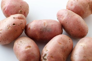 Bir sürü pis patateslerin üzerine beyaz bir arka plan. Beyaz bir arka plan üzerinde dağınık patates.