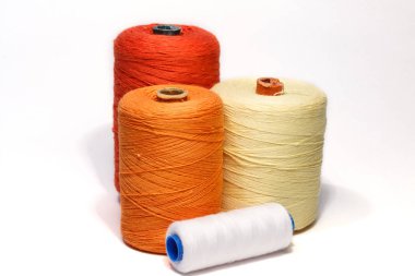 Dikiş malzemeleri. Bobin ile renkli iplik. Dört makara renkli iplik beyaz, sarı, turuncu ve kırmızı iplik.