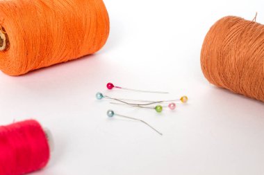 Biriktiricileri renkli iplik ve beyaz bir arka plan iğne falan batmazdı. İş parçacığı turuncu, kırmızı ve kahverengi biriktirme.