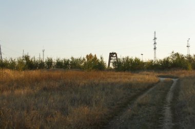 Günbatımı bir alanın tahıl ile toprak ufuk doğru giden yol üzerinde.