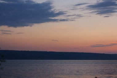 Nehrin arka planda günbatımı. Gün batımı ışık büyük bulutlar.