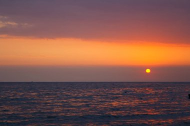 Denizin üzerinde gün batımı.