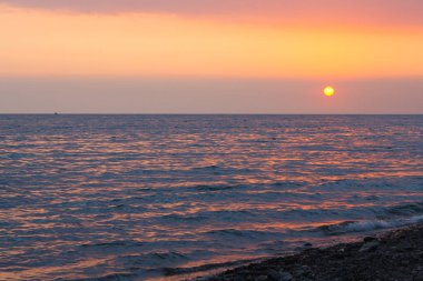 Denizin üzerinde gün batımı.