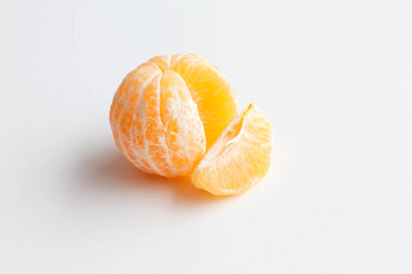 Mandarin isolated on white background. One peeled tangerine and a slice of Mandarin.