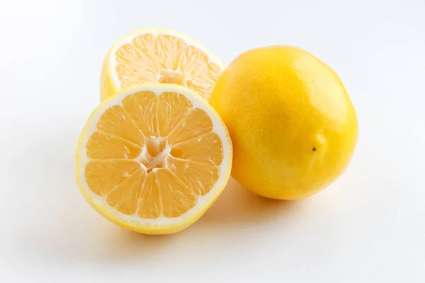 Lemon cut in half. Two halves of a lemon lying next to a whole lemon. — Stock Photo, Image