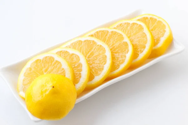 Sliced lemon circles into pieces. Slices of lemon lying on the plate. — Stock Photo, Image