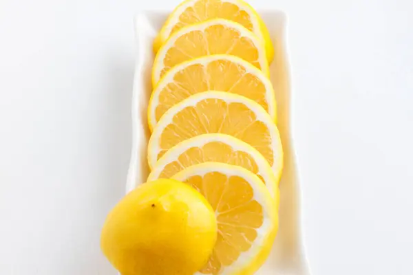 Skivad citron cirklar i bitar. Skivor av citron liggande på plattan. — Stockfoto
