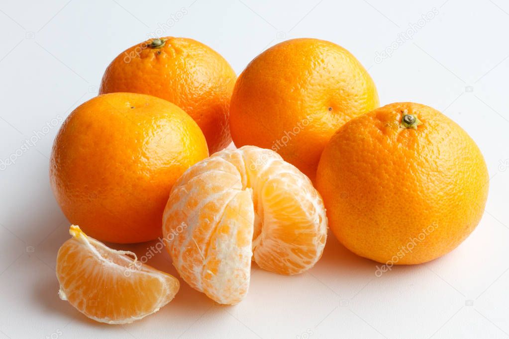 Mandarin isolated on white background. Five Mandarin lie side by side. One peeled tangerine and a slice of Mandarin.
