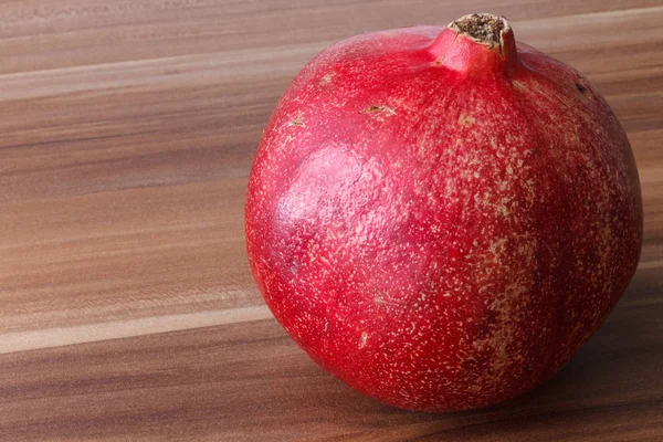 Granatäpple ligger på ett träbord. — Stockfoto