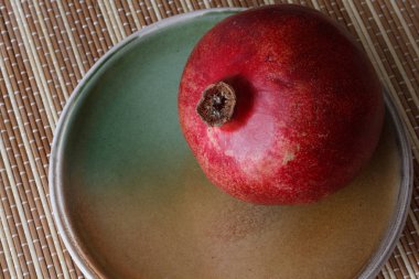 Olgun kırmızı nar meyve bir kil plaka üzerinde yatıyor.