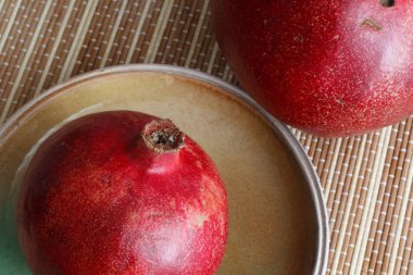 Olgun kırmızı nar meyve bir kil plaka üzerinde yatıyor.