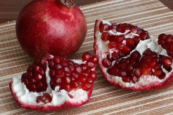Pomegranate fruit cut in half. Bright juicy ripe pomegranate seeds. — Stock Photo, Image