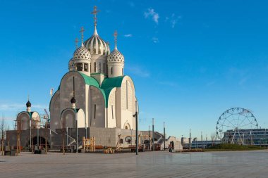 Mavi gökyüzüne karşı inşa edilmiş alışılmadık bir Ortodoks kilisesi. Arka planda dönme dolabı görebilirsiniz..